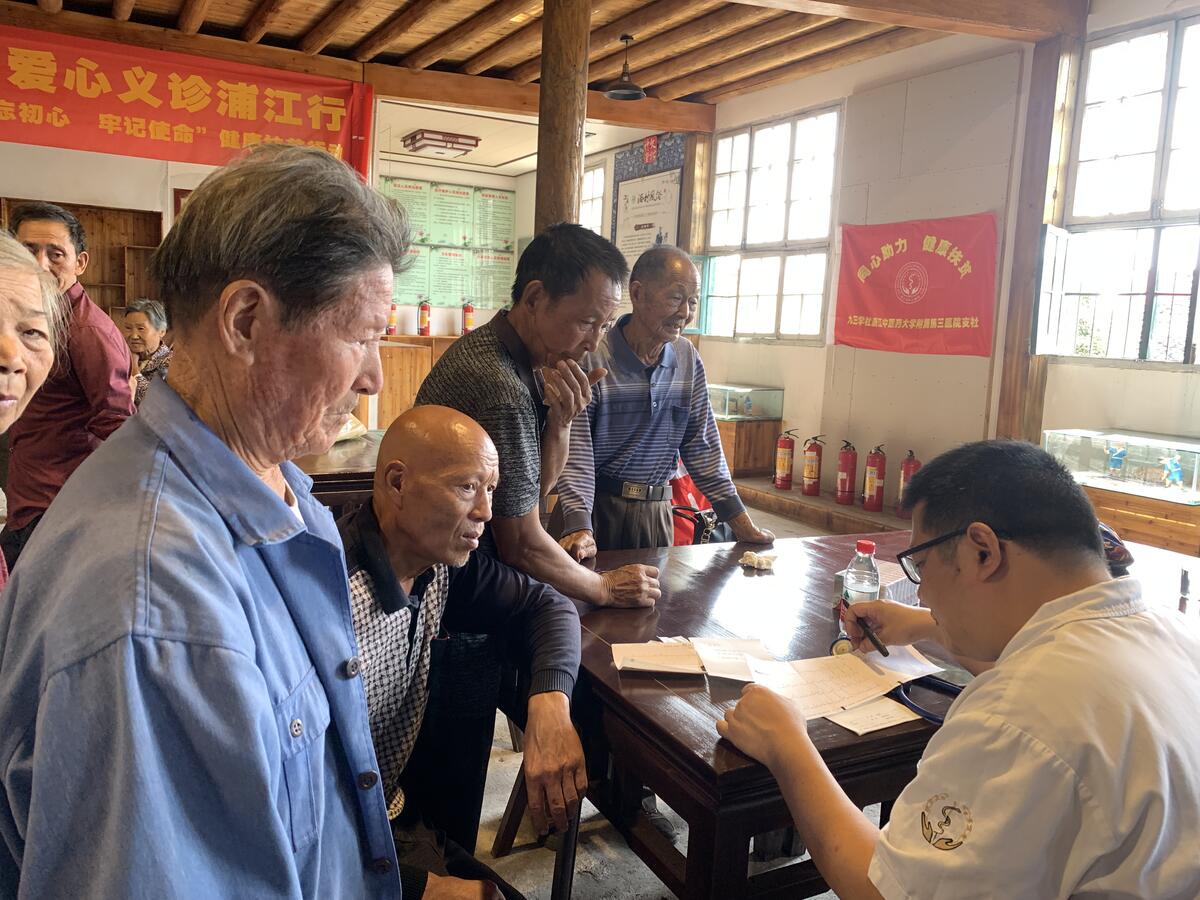 丁学军副主任在为村民诊治.jpg